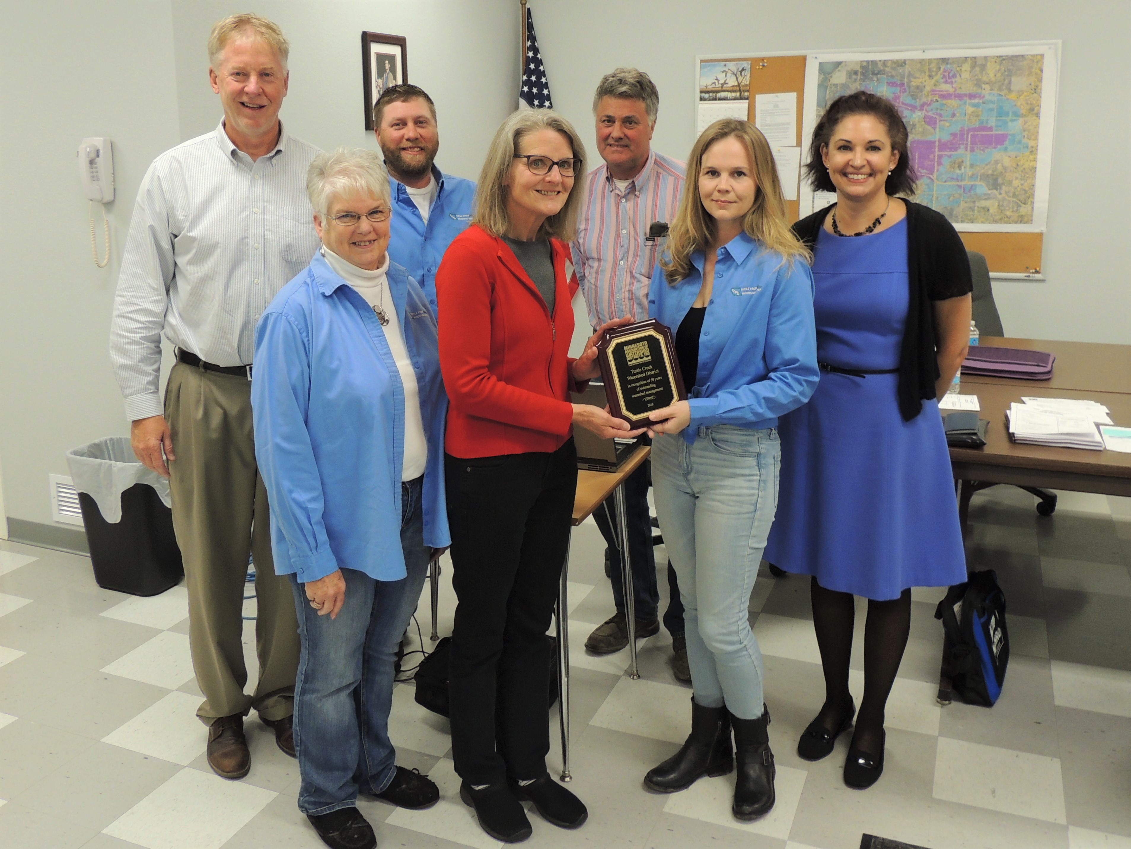 Minnesota Association of Watershed Districts (MAWD) board president Ruth Schaefer presents TCWD board chair Michelle Miller on May 21 with a plaque honring the district's 50th anniversary of water-management efforts. MAWD executive director Emily Javens (far right) along with TCWD board and staff are pictured as well. 

